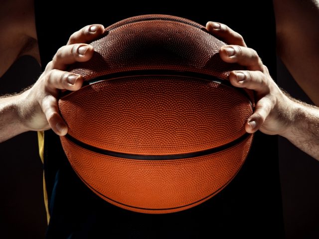 silhouette-view-basketball-player-holding-basket-ball-black-wall